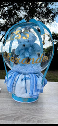 Blue teddy bear in a transparent ball with decorative elements on a wooden surface - Lovy Details Miami