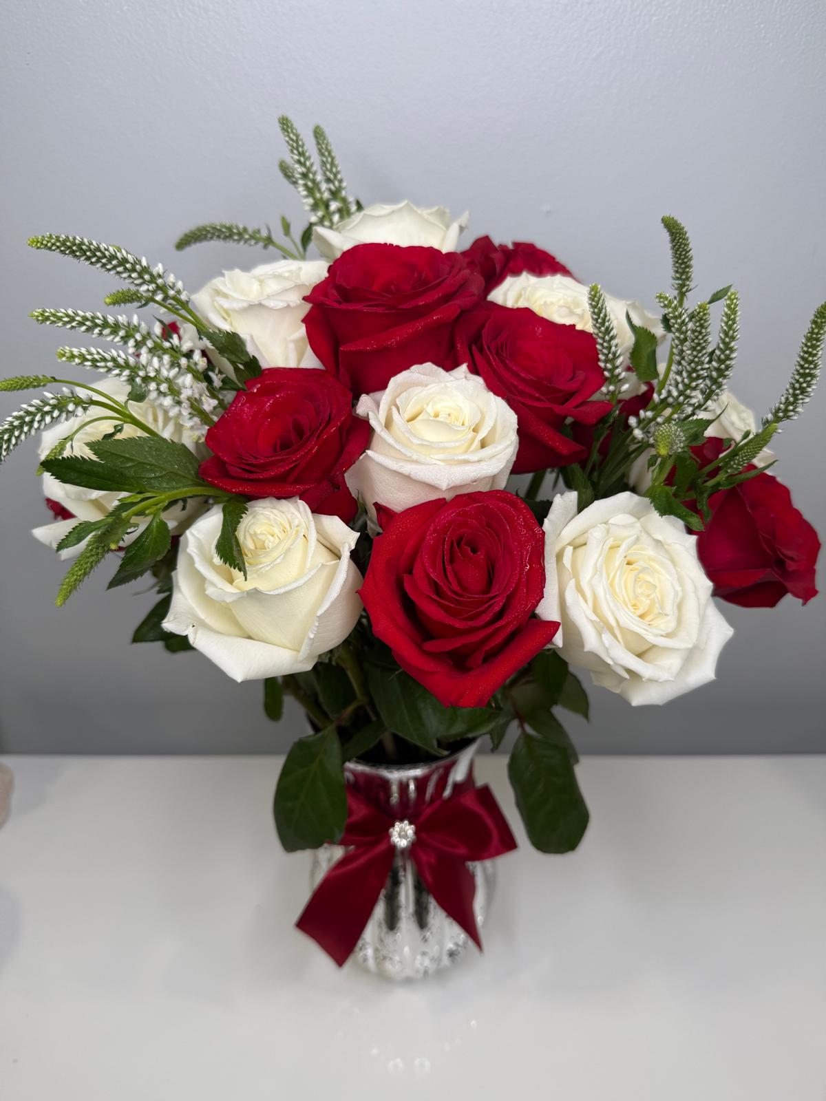 Bouquet of red and white roses in a vase with a decorative bow on a gray background - Lovy Details Miami
