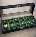 Watches box with green and gold 'Happy Birthday' jewelry pieces on a stone surface - Lovy Details Miami